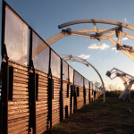 Image: This composite image displays the vision of MacMurtrie’s ongoing Border Crossers project: Six inflatable robotic sculptures rise up to several stories high and extend across the U.S.-Mexico border. The Border Crossers are depicted in different stages of activation: deflated, activated, and fully deployed over the border fence.