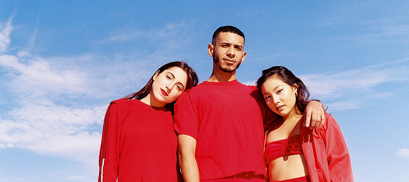 Image of three individuals wearing red clothes against a blue sky