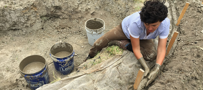 Artist Bel Falleiros molds concrete into a gash on the dirt. 