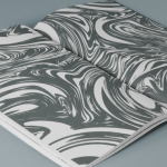 This is an image of a book open to a spread. The spread comprises marbleized paper in gray-and-white tones.