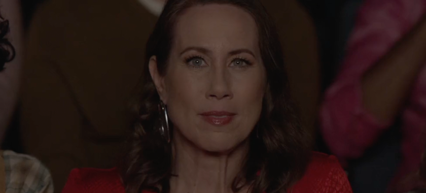 Close up film still of Miriam Shor as Harriet, with red dress and red lipstick, nervous and excited, in a cinema in "MAGIC HOUR"