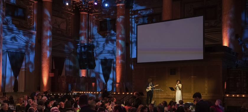 View of the Capitale event space, with Pyeng Threadgill performing onstage with a guitarist underneath a large screen