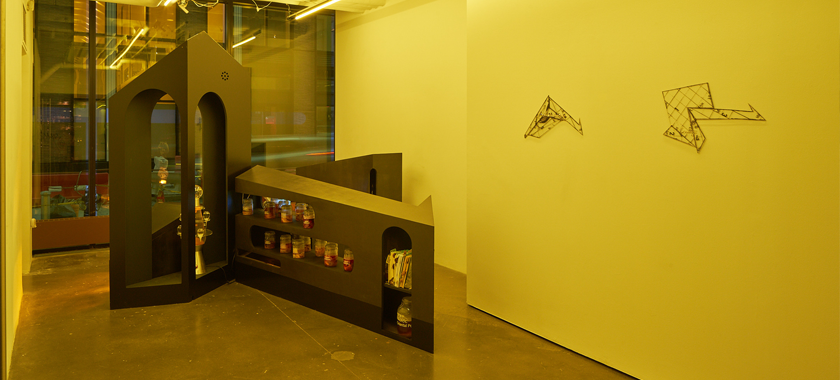 Image Detail: Yellow-hued photograph of a large sculptural installation in a New York gallery space with yellow walls and a window facing the street.