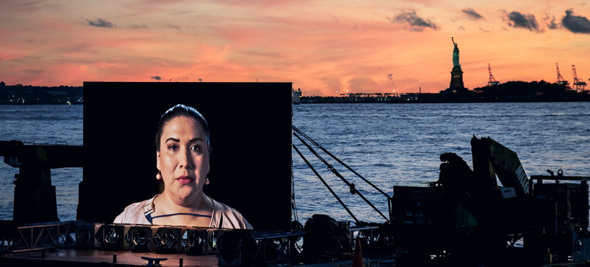 Photograph of "Night Watch," a floating installation that circulated in NYC’s waterways during Fall 2018. The artwork featured a 20ft-wide LED-screen which travelled the city’s waterways aboard a large, slow-moving barge and tug boat.