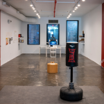 Gallery installation featuring various weapons and punching bags