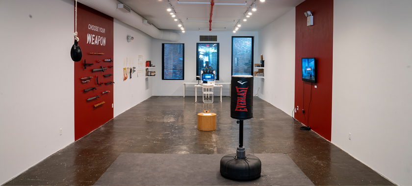 Gallery installation featuring various weapons and punching bags