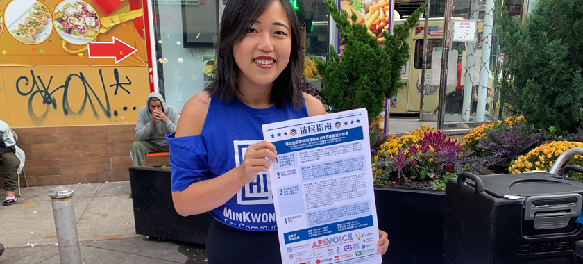 An individual wearing a MinKwon tee holding a flyer
