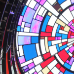 An image of a colorful stained glass watertower interior, as viewed from below