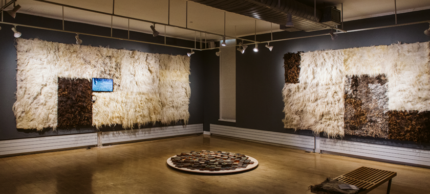 Installation shot of an exhibition by Brigitta Varadi, with wool artworks on the wall