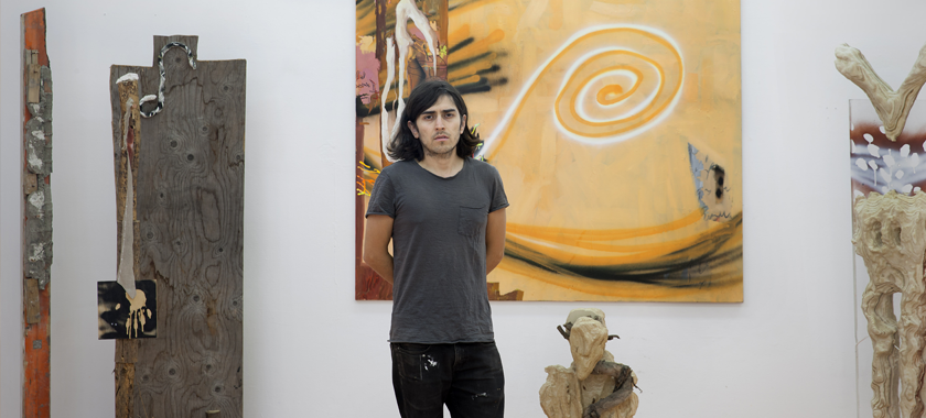 Portrait of Esteban Cabeza de Baca, photographed against a white wall in front of their works