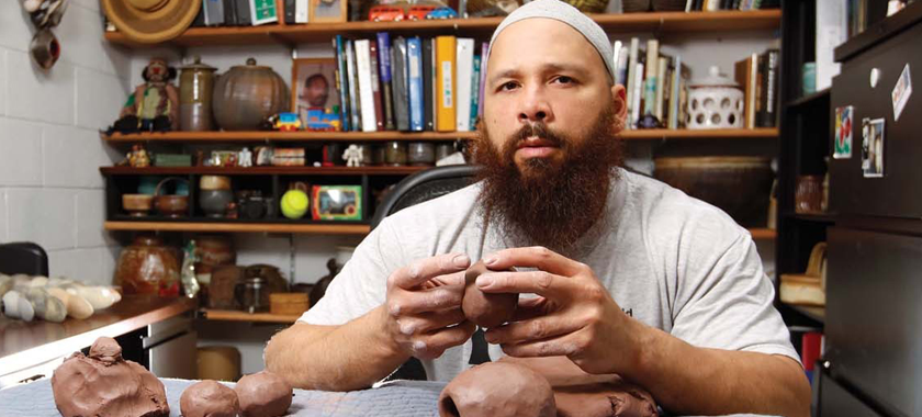 Sharif Bey photographed in studio, working with clay