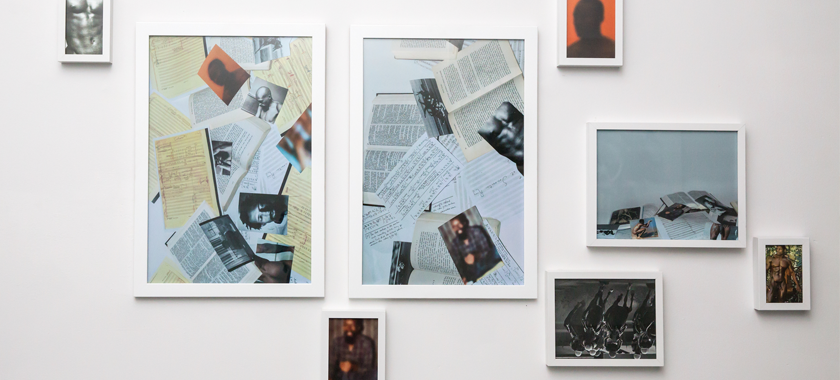 Installation view of a series of images, some with a collaged nature, and some of the male body, on a white gallery wall