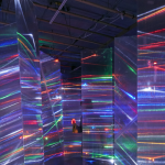 Installation by Barbara Campisi featuring screens of a semi-transparent acrylic material with small bands of neon lights across it