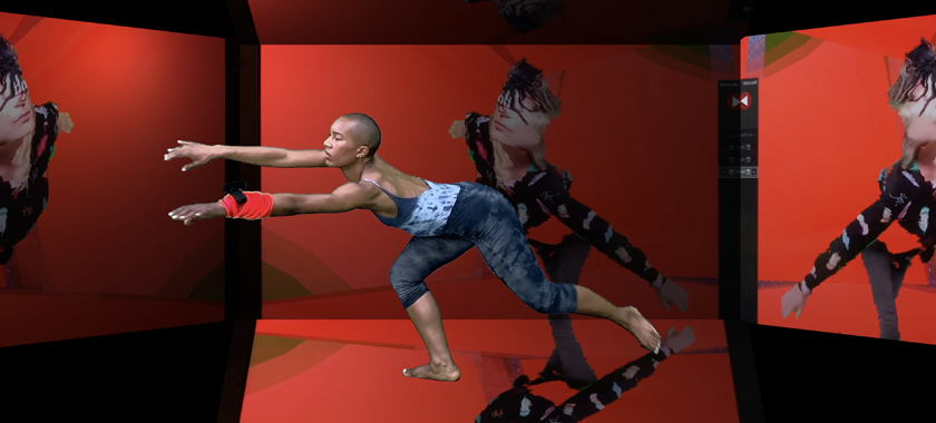 A digitally rendered dancer extends her arms in a mostly red, open-box-like virtual space, featuring a glitchy image of another performer who has a smartphone tied over her eyes. The dancer has a webcam tied to her wrist, using a bright red tube as a rope.