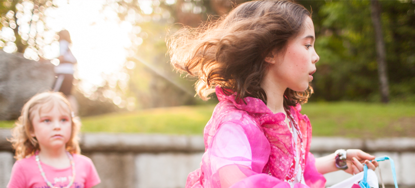 Children, assigned male at birth, dress as they choose at a weekend summer camp where they are supported to express themselves as they like, without judgement. Here two campers prepare for the annual fashion show dressed in layers of pink on warm sunny day.