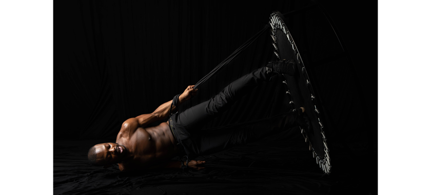 Dancer Ezra Swift photographed against a dramatic black background