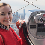 Photo of Mary-kate Grohoski with a viewmaster, high on a city skyscraper