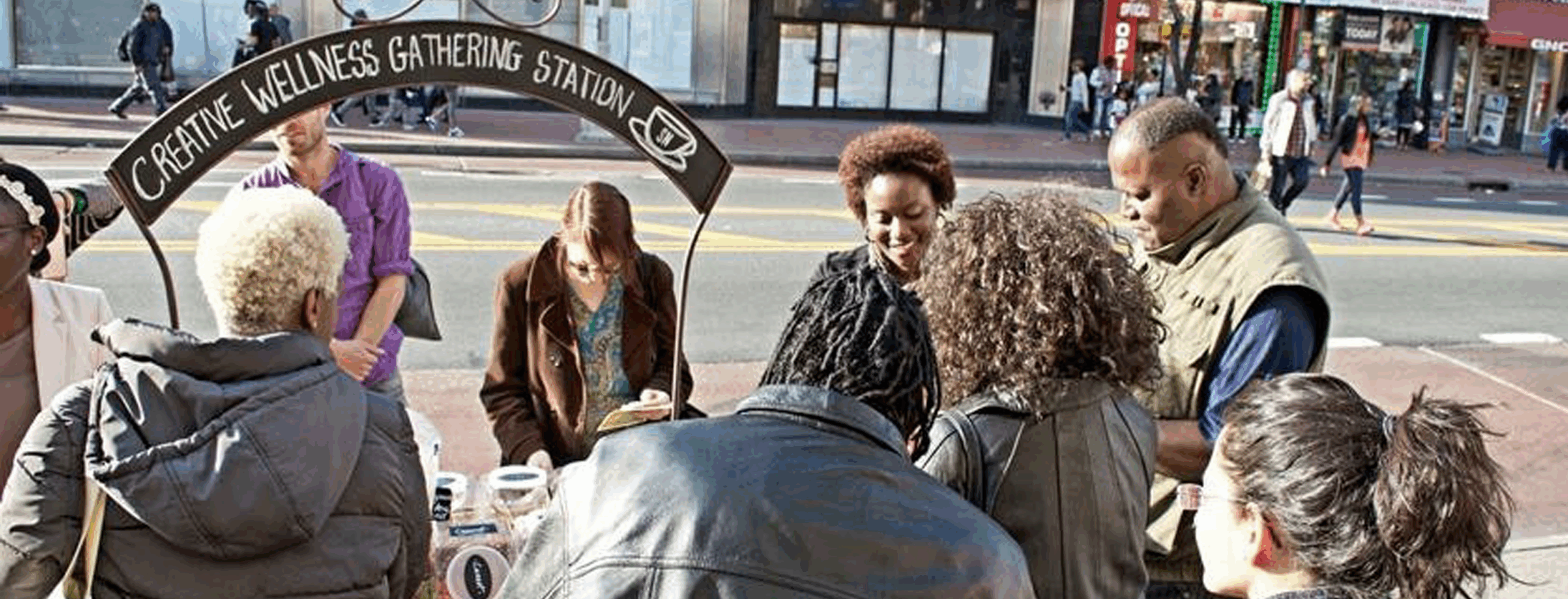 Artist Shervone Neckles is with her Creative Wellness Gathering Station, mobile tea cart on Jamaica Avenue in 2016. Neckles is engaging the public in conversation and inviting cart visitors to mix and make their own wellness tea blends.