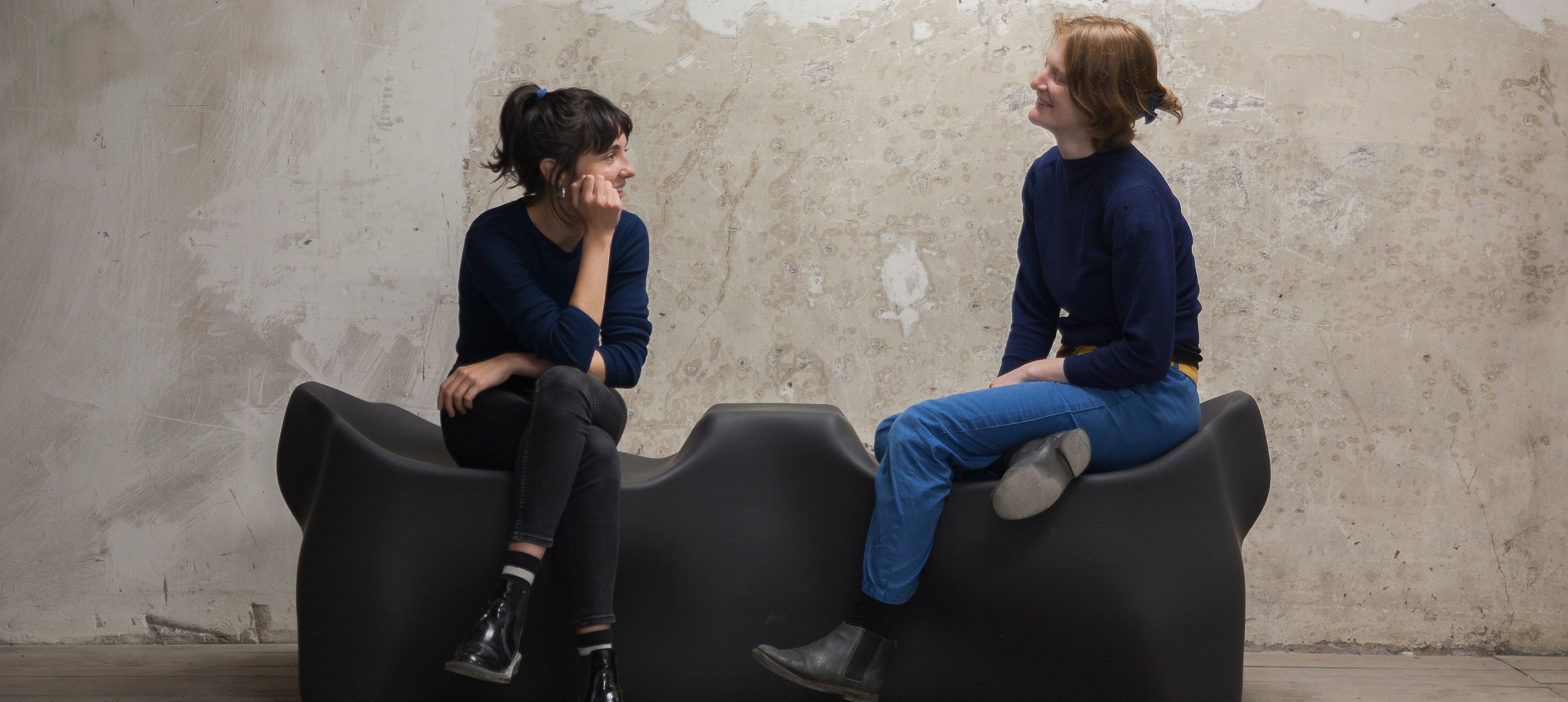 Two individuals sitting in conversation on furniture designed by Tyler Coburn with Bureau V