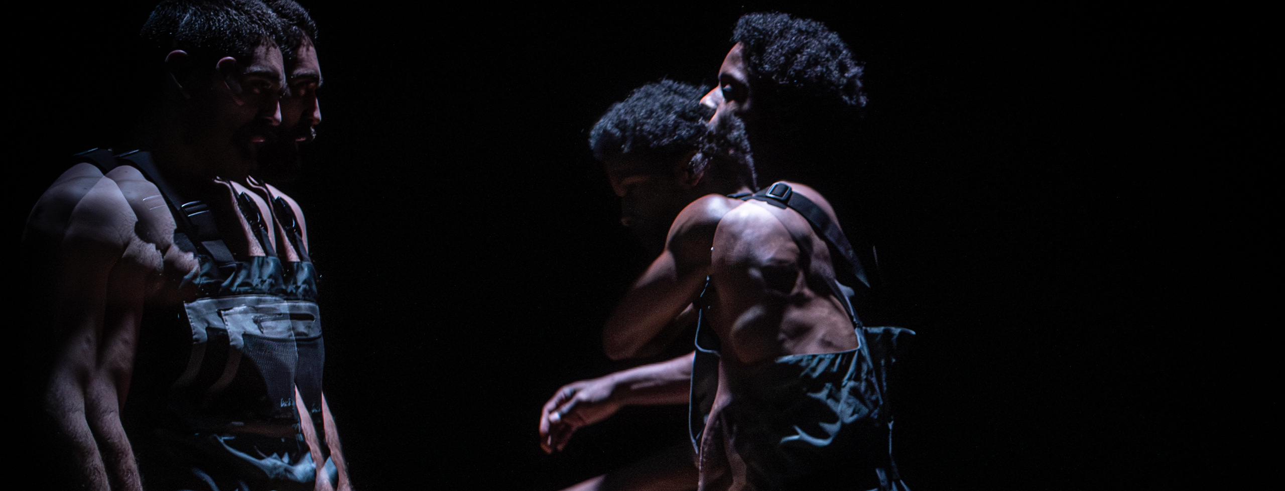 A white man and black man face each other. Both are in motion. The image is double exposed.