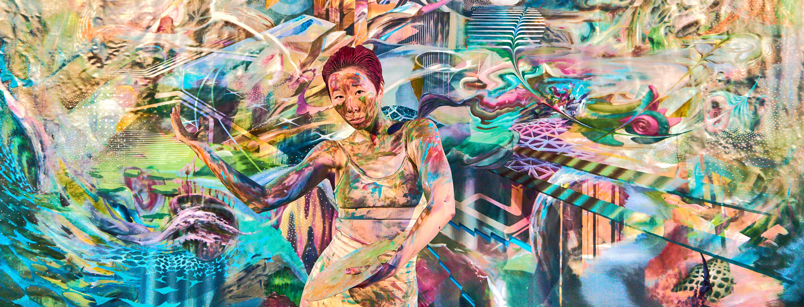 A woman posing and blending into the artwork behind her.