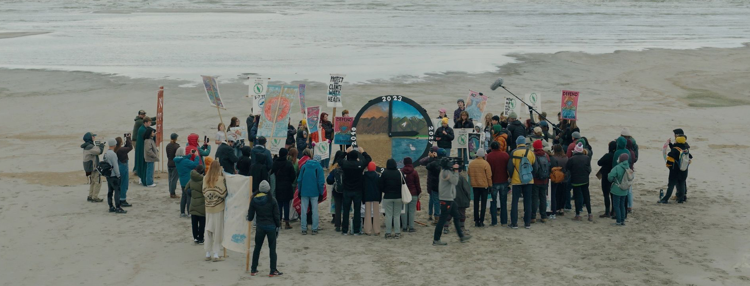 Dozens of youth activists gather around a giant clock on the shoreline of Great Salt Lake