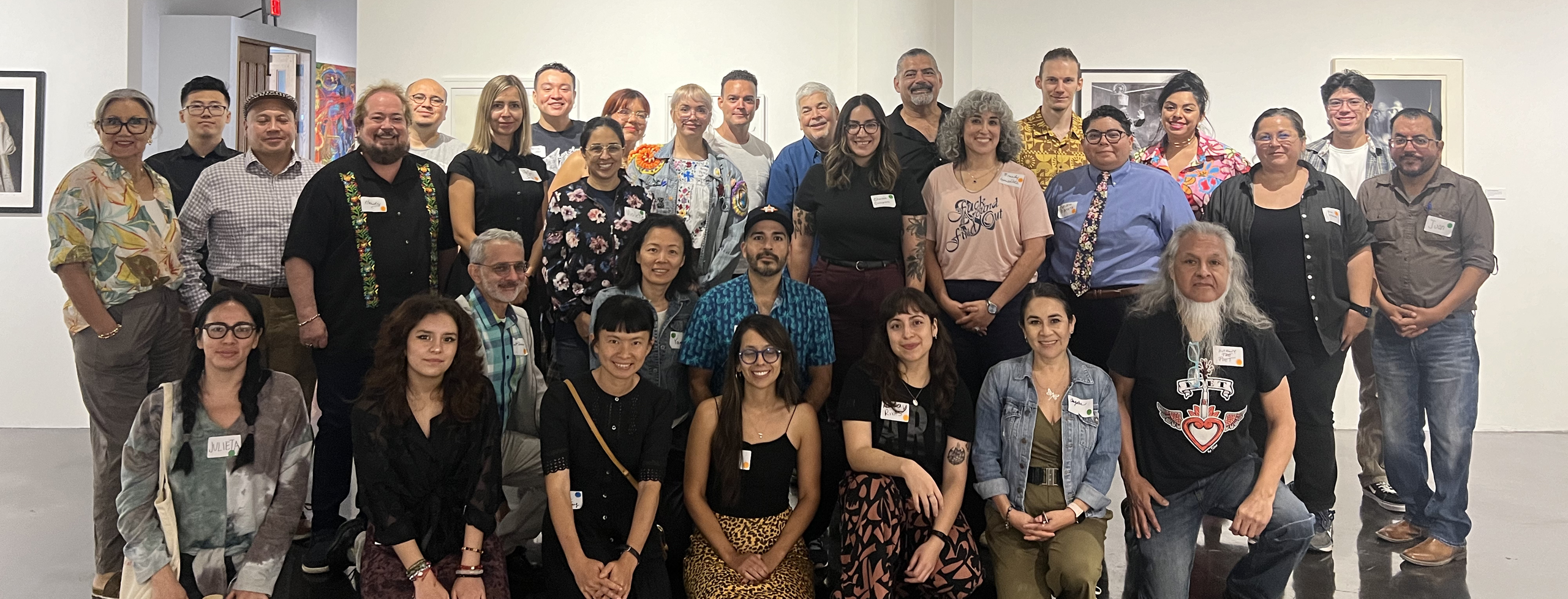 Immigrant Artist Mentoring Program: San Antonio participants smiling and posing for a photo in a white-walled gallery space