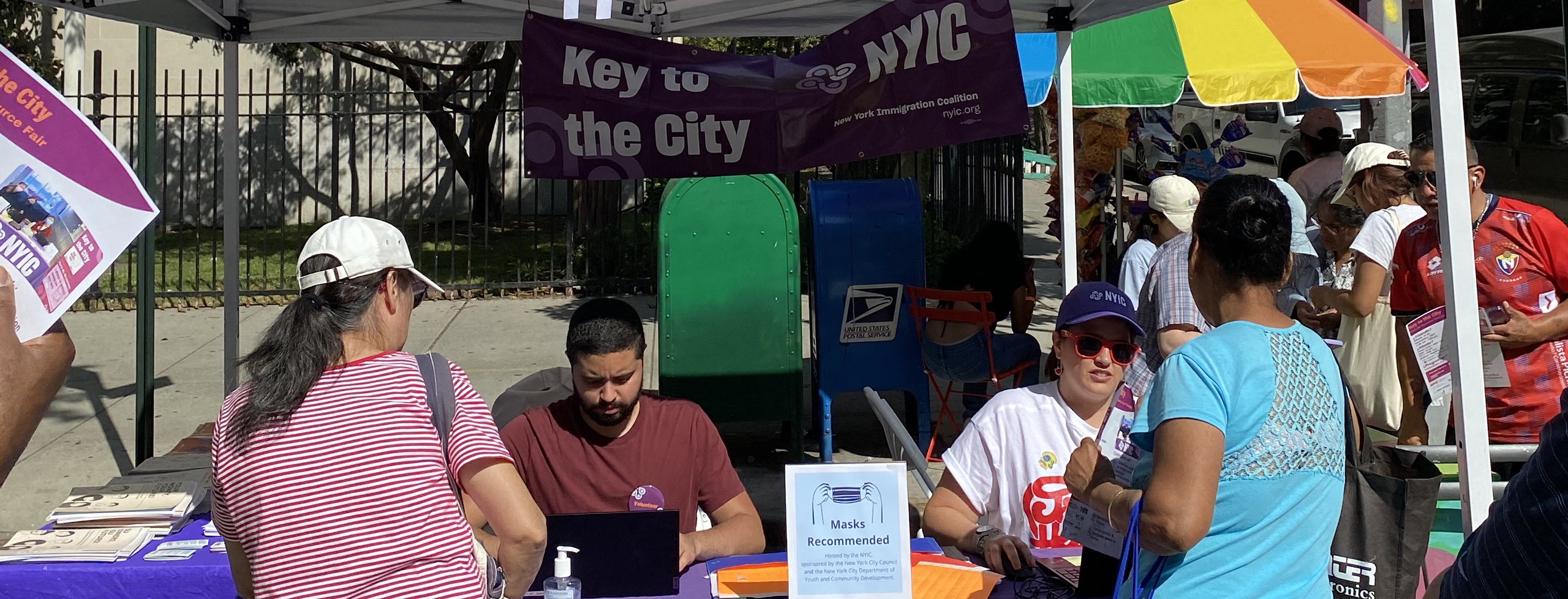 Photo of two representatives from NYIC tabling at the "Key to City," speaking with attendees