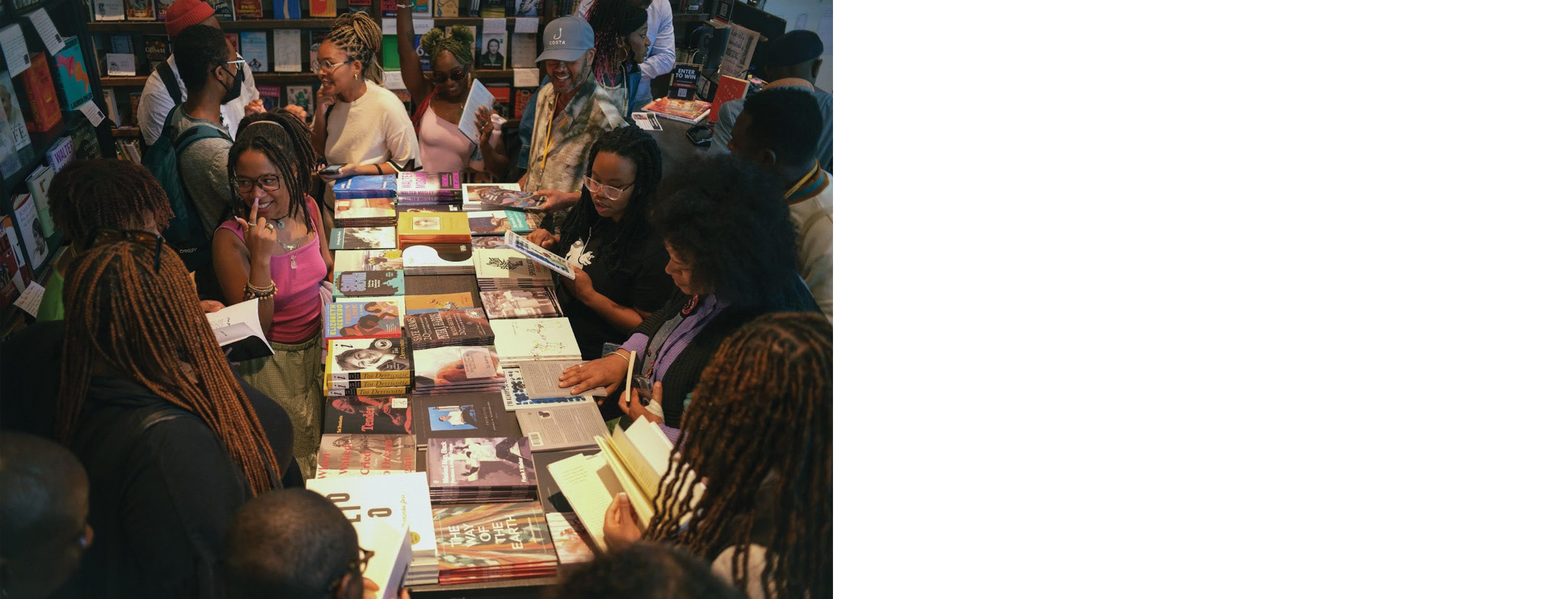 More than a dozen people gather in a bookstore, talking excitedly.