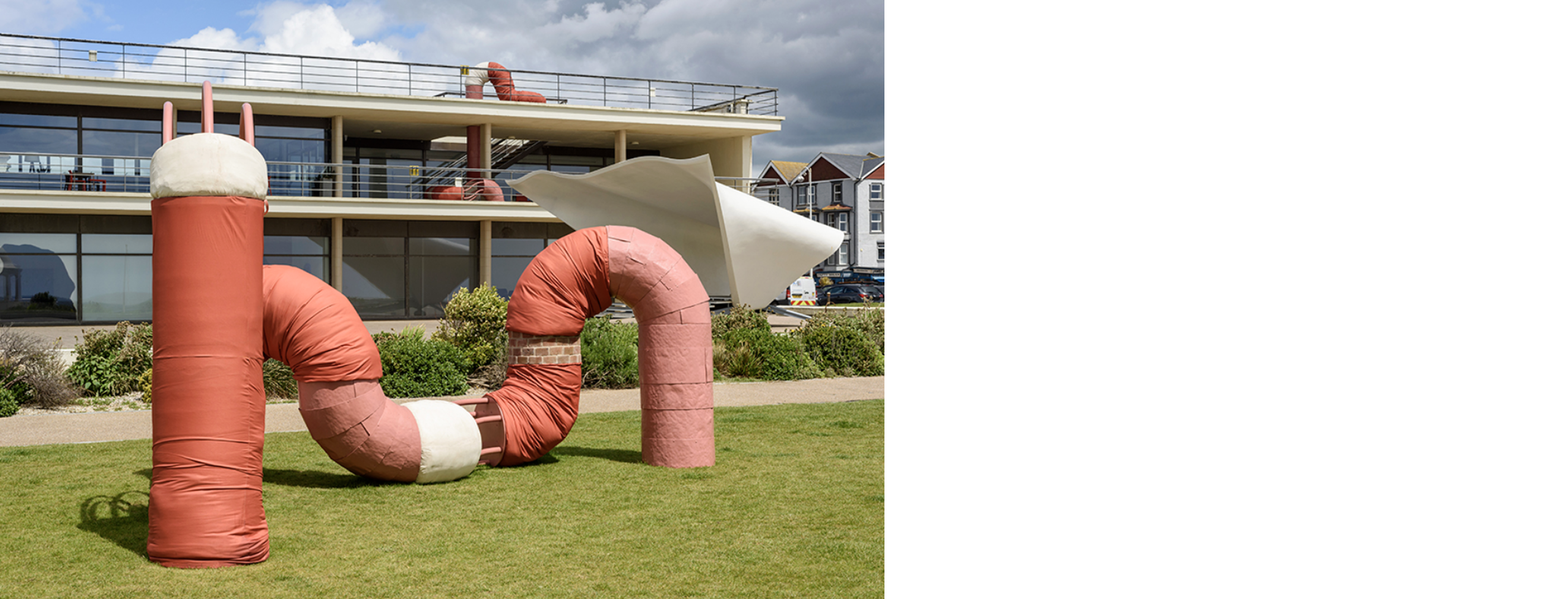 Large outdoor sculpture; a giant composite form that has wormed its way around the outside of De La Warr Pavilion in England, stretching from the seafront lawn to the first floor balcony and the roof